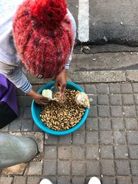 High angle view of woman holding ice cream on footpath