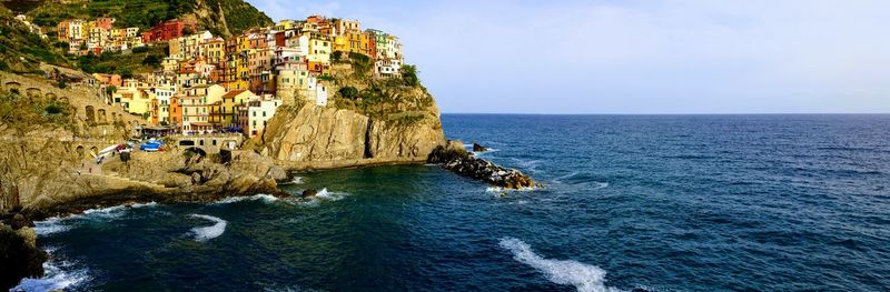 Scenic view of sea by cliff against clear sky