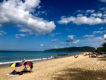 Group of people on beach against sky