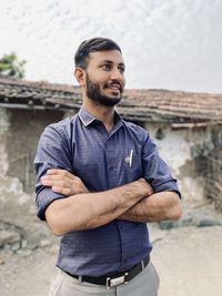 Portrait of young man standing against wall