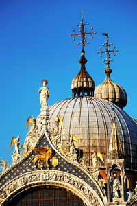 Statues and carvings on saint mark basilica against clear blue sky