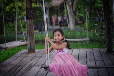 Portrait of smiling girl standing on wood