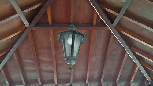 Low angle view of electric lamp hanging from ceiling