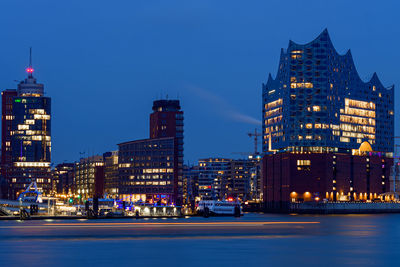 Illuminated buildings against sky at night