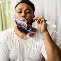 Close-up portrait of man holding bubbles