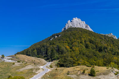 Scenic view of mountains against clear blue sky