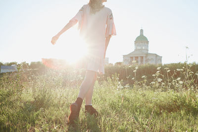 Woman on field against bright sun