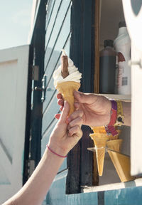 Close-up of hand holding ice cream on sunny day
