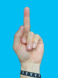 Close-up of human hand against blue background