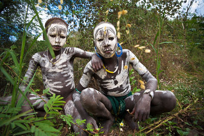 View of boy sitting in forest