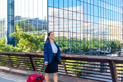 Full length of woman standing against buildings in city