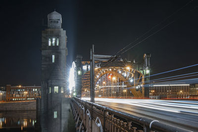 Light trails on road against buildings at night