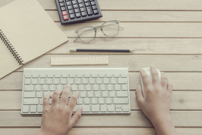 Directly above shot of person hands using computer mouse and keyboard