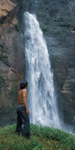 Full length of shirtless man standing in water