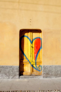 Close-up of heart shape graffiti on wall and door