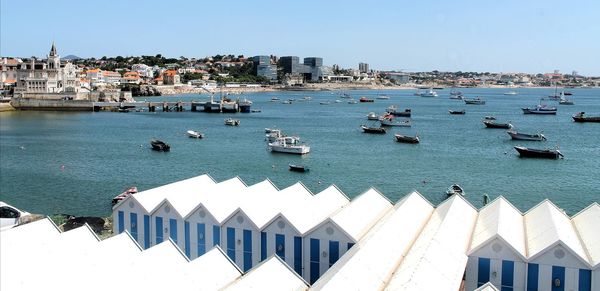 High angle view of buildings by sea against clear sky