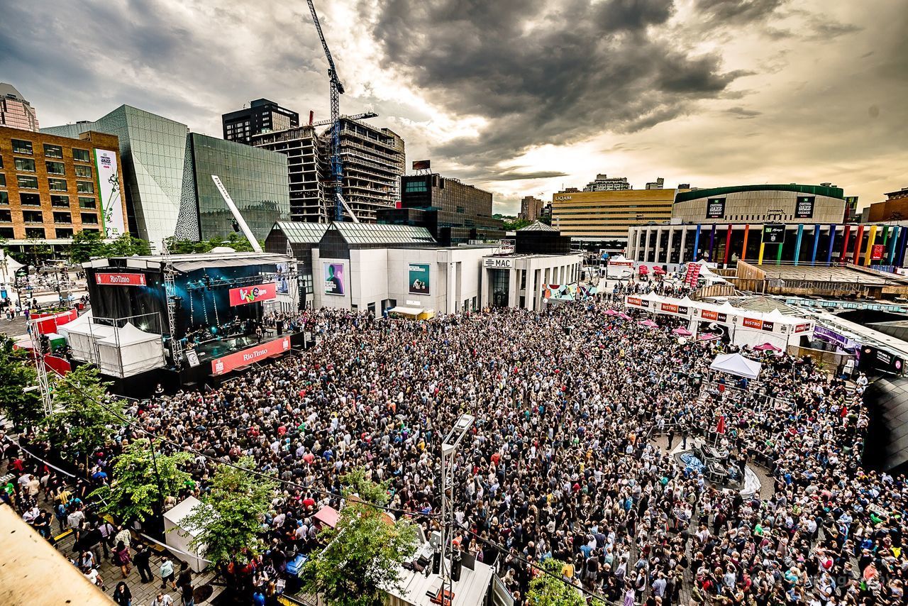 CROWD ON ILLUMINATED CITY AGAINST SKY