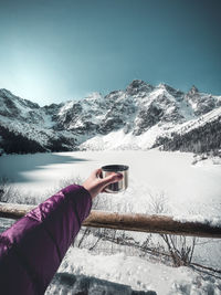 Cropped hand of woman holding cup of coffee winter adventure 