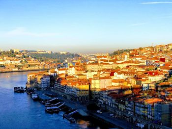 High angle view of city by river against sky