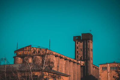 Low angle view of old building against clear blue sky