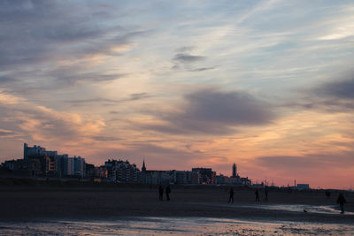 View of beach against cloudy sky during sunset