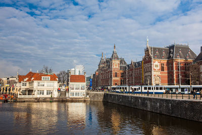 Canals, central railway station and tram at the old central district of amsterdam