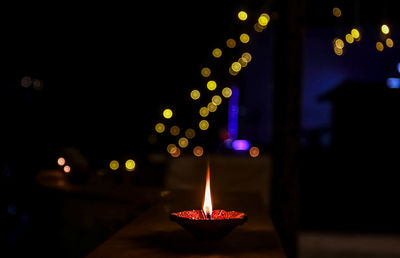 Illuminated candles on fire at night