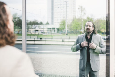 Businessman standing against window outdoors