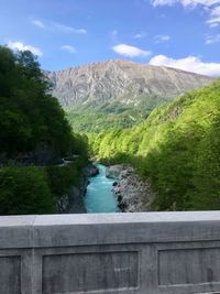 Scenic view of river by mountains against sky