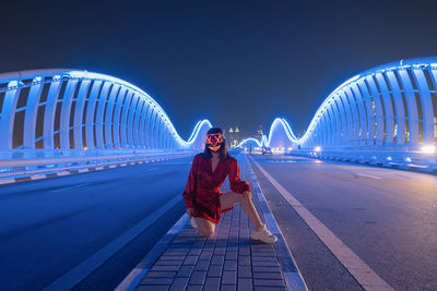 Full length of man on illuminated bridge against sky at night