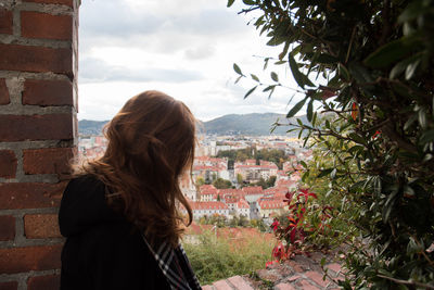 Rear view of woman standing by window