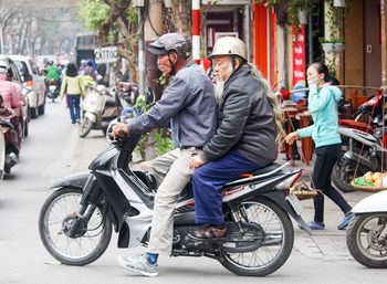 People riding motorcycle on road