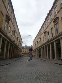 Man in city against sky