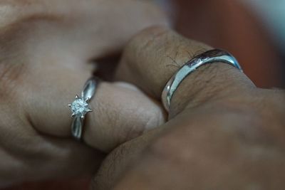 Cropped hands of couple wearing finger rings