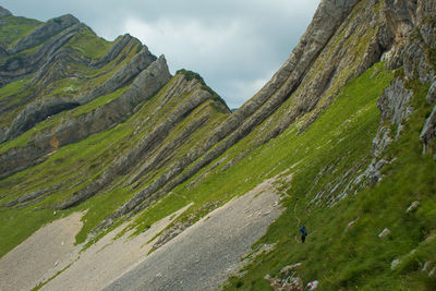 Panoramic view of green landscape and mountains against sky