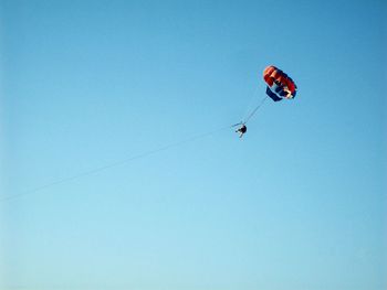 Low angle view of kite against clear blue sky