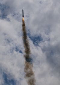 Low angle view of airplane flying against sky