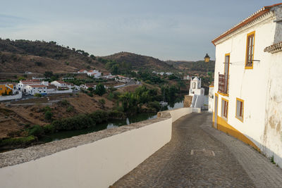 Street amidst buildings in town against sky