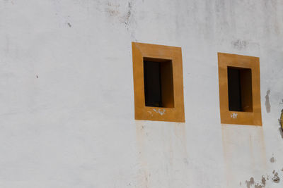 Low angle view of yellow window on white wall