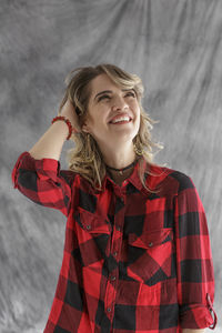 Young woman standing against backdrop