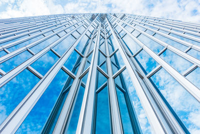 Low angle view of glass building against sky