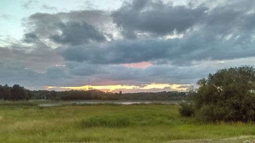 Scenic view of field against cloudy sky