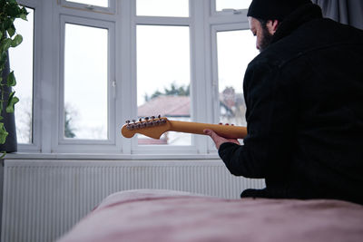 Man playing guitar at home