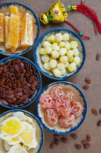 Directly above view of food in bowls with scattered seeds on table