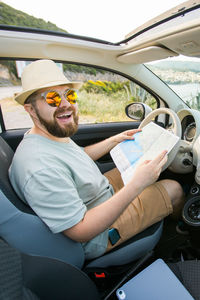 Portrait of smiling couple sitting in car