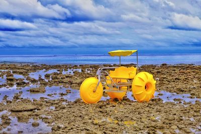 Yellow umbrella on beach against sky