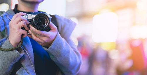 Midsection of man photographing with camera