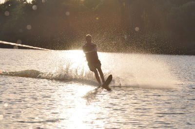 Front view of person water skiing at sunset