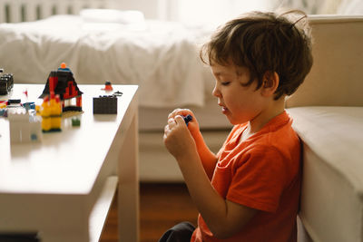 Cute boy is playing constructor at home. kid playing block toys in home at nursery.