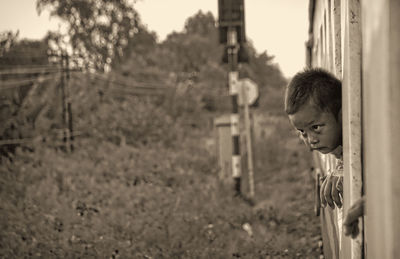 Portrait of boy looking through fence